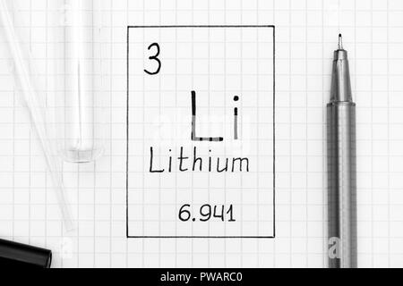 Tavola periodica degli elementi. La grafia elemento chimico litio Li con la penna nera, tubo di prova e la pipetta. Close-up. Foto Stock