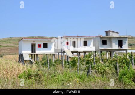 Case su palafitte dipinte con la bandiera albanese divjake albania Foto Stock