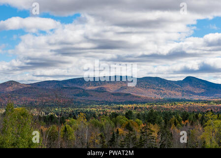 Un autunno vista delle Montagne Adirondack guardando ad est dal Lago indiano in New York, Stati Uniti d'America con cielo blu e nuvole bianche che gettano ombre sulle montagne. Foto Stock