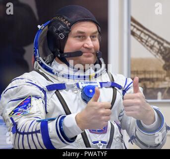 Expedition 57 Tecnico di volo Alexey Ovchinin di Roscosmos dà un pollice in alto dopo aver la sua tuta Sokol controllato di pressione prima del suo lancio su un razzo Soyuz con tecnico di volo Nick aia della NASA, presso il cosmodromo di Baikonur Ottobre 11, 2018 di Baikonur in Kazakhstan. Poco dopo il sollevare il malfunzionamento del razzo in rotta verso la stazione spaziale internazionale e interrotta la forzatura di un atterraggio di emergenza in Kazakistan. I membri di equipaggio sono stati prelevati da ricerca e soccorso e secondo come riferito sono in buone condizioni. Foto Stock