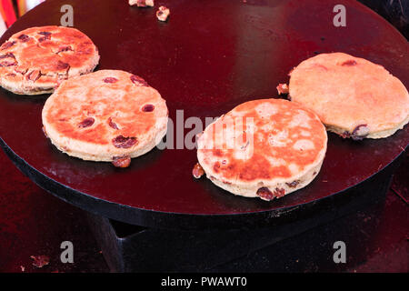 Torte gallesi cottura su una piastra piatta della piastra. Foto Stock