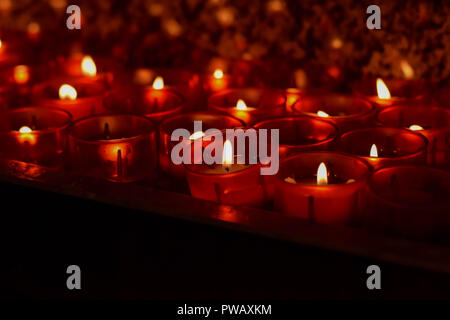 Combustione lenta candele di cera nella chiesa come simbolo di morte la memoria. Macro scuro vicino composizione con profondità di campo Foto Stock