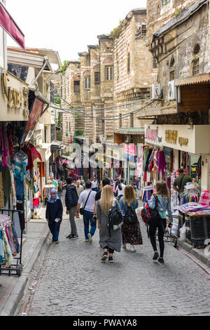 File di negozi con merci sulla linea di visualizzazione una zona collinare strada di ciottoli con cittadini e turisti a piedi lungo di esso nel distretto di Fatih, Istanbul, Turchia Foto Stock