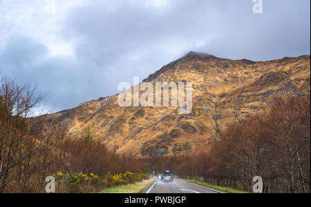 Strada che conduce verso le cinque sorelle di Kintail parzialmente in nuvole, West Highlands, Scotland, Regno Unito Foto Stock
