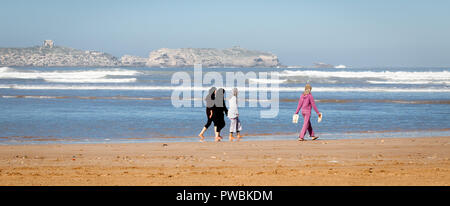 Marocco Essaouira un gruppo di quattro giovani donne locali di indossare il velo islamico camminare a piedi nudi sulla spiaggia Foto Stock