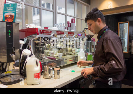 Un caffè costa barista in un duro lavoro, London, Regno Unito Foto Stock