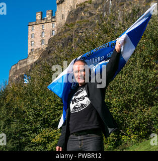 Tommy Sheridan, indipendenza scozzese sostenitore sventolando sì si intraversa bandiera Tutti sotto uno striscione AUOB marzo, il Castello di Edimburgo, Scozia, Regno Unito Foto Stock