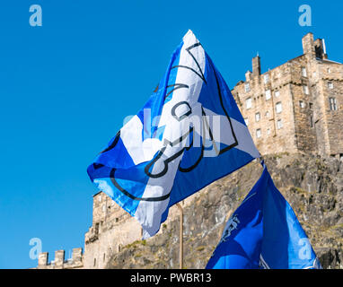 Indipendenza scozzese sì St Andrews Cross si intraversa bandiera a Tutti sotto uno striscione marzo 2018, il Castello di Edimburgo, Scozia, Regno Unito Foto Stock