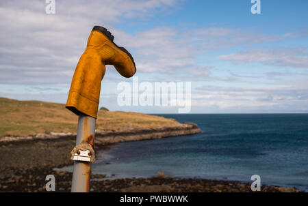 Una gomma gialla boot mettere su un montante metallico pilastro, Isola di Skye, Scotland, Regno Unito Foto Stock