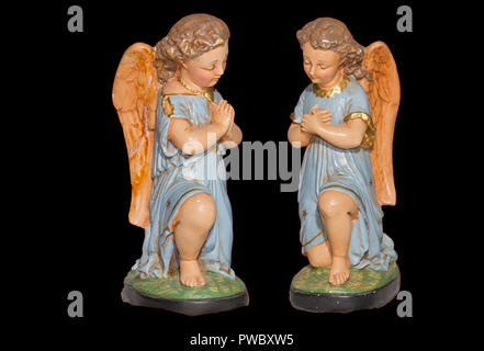 Due angeli in preghiera con il vestito blu, gesso, statue in gesso e dipinte a mano, isolata su dark sfondo rosso Foto Stock