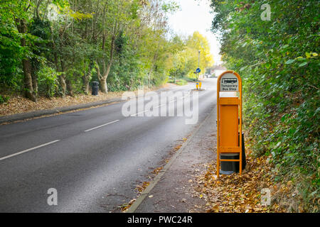 Bus temporanea segno di stop in un villaggio rurale strada alberata con nessun traffico, hamstreet, kent, Regno Unito Foto Stock