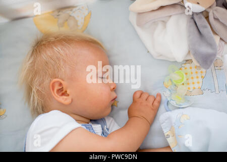 Little baby boy, dorme nel letto per bambino con succhietto nelle vicinanze Foto Stock