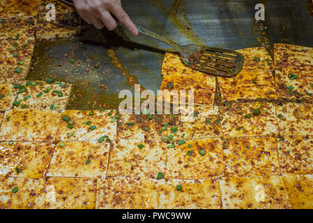 La cottura stir-tofu fritto con salsa piccante in un chniese street market, Chengdu Cina Foto Stock