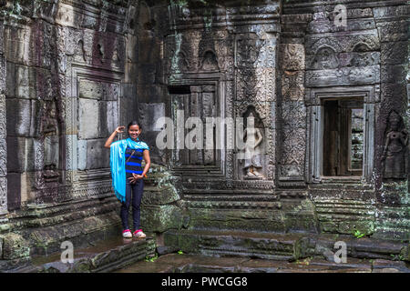 Ragazza cambogiano pone come una statua apsarasa a Angkor Kdei tempio vicino a Siem Reap. Foto Stock