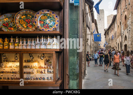 Visualizzazione di elementi colorati in un negozio di souvenir e turisti nella cittadina collinare di San Gimignano, Toscana, Italia Foto Stock