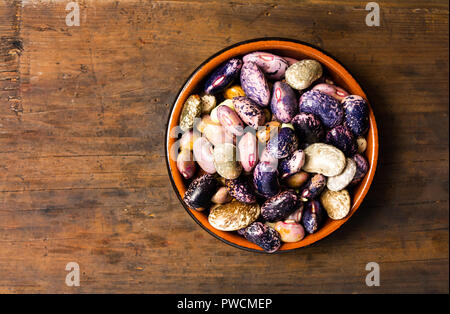 Fagioli naturale in una ciotola su una tavola di legno Foto Stock