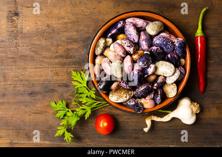 Fagioli naturale in una ciotola su una tavola di legno Foto Stock