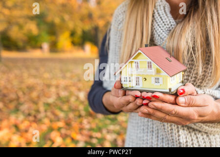 Giovani amare giovane azienda modello piccolo casa in autunno parco o giardino Foto Stock