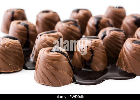 Pezzi di bomboni ricoperti di cioccolato fuso isolato su sfondo bianco Foto Stock