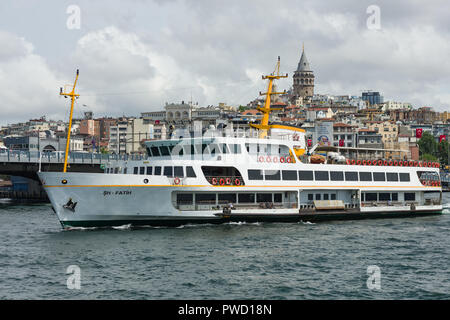 Un grande traghetto passeggero arriva al porto di Eminonu con Torre di Galata in background, Istanbul, Turchia Foto Stock