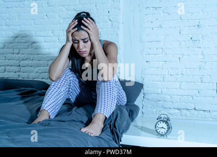 Insonne e disperato bella donna latina sveglio di notte non è in grado di dormire guardando l'orologio che soffrono di insonnia in disturbo del sonno concetto. Foto Stock