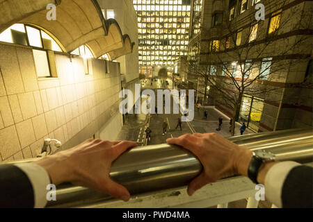 Punto di vista personale lasso di tempo di un imprenditore caucasico appoggiandosi con le mani sulle ringhiere di notte Foto Stock