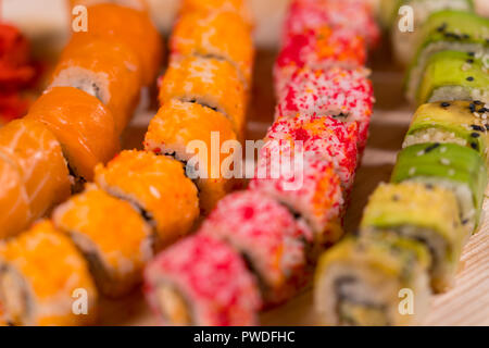 Colorato assortimento di sushi rotoli su una piastra circolare su un tavolo da buffet in un vicino la vista dal di sopra con dof poco profondo Foto Stock