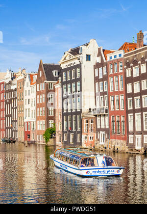 Case di Amsterdam su Damrak Una parzialmente riempito nel canale con una gita in barca, architettura olandese dal canal Damrak Amsterdam Holland Olanda UE Foto Stock