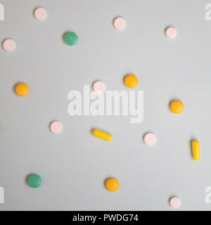 Modello di bianco, verde e arancione pillole e compresse su uno sfondo blu. Assortiti medicina farmaceutica pillole, laici piatta Foto Stock