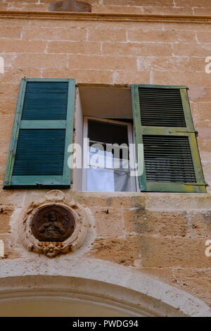 Lapide raffigurante Cristo al di sotto della metà aprire persiane verdi Ciutadella menorca Spagna Foto Stock