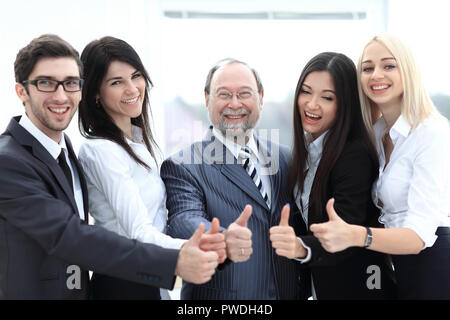 Primo piano della testa e il team Aziende che mostra il pollice verso l'alto. Foto Stock