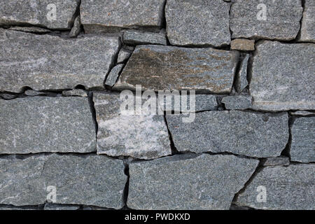 Close-up di roccia di granito blocchi uniti senza malta formando una parete di alpine rifugio di montagna Foto Stock