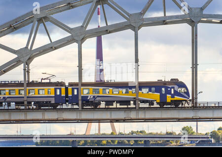 Ferrovie lettoni treno passando sopra il ponte della ferrovia, Riga, Lettonia, oltre il fiume Daugava Foto Stock