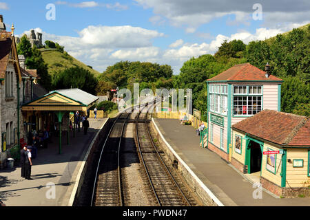 Corfe Castle stazione sulla ferrovia a Swanage, dominato dai ruderi del castello antico. Foto Stock