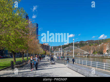 Passeggiata lungo il fiume Nervion guardando verso il ponte Zubizuri, Muelle de Urbitarte, Bilbao, Paesi Baschi Foto Stock