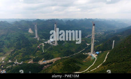 (181015) -- GUIYANG, Ott. 15, 2018 (Xinhua) -- In questa foto aerea adottate il 7 settembre 25, 2018 lavoratori di costruire il ponte Pingtang del Pingtang-Luodian expressway nel sud-ovest della Cina di Guizhou. L'altezza di uno del Ponte delle Torri di misura 328 metri. Una volta completato, il Pingtang Birdge sarà il più alto ponte di cemento nel mondo. Nel sud-ovest della Cina di Guizhou, dove infinite colline carsiche dominano la terra, con i moderni mezzi di trasporto è reso possibile grazie a più di 20.000 ponti che attraversano sopra le valli. La provincia facilmente giustifica di per sé come un museo di ponti: amo Foto Stock