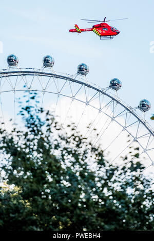 Londra, Regno Unito. 16 ottobre, 2018. La Air Ambulance prende il largo tra St James Park e Whitehall e sorge oltre i turisti sul London Eye dopo un incidente stradale a Westminster. Credito: Guy Bell/Alamy Live News Foto Stock