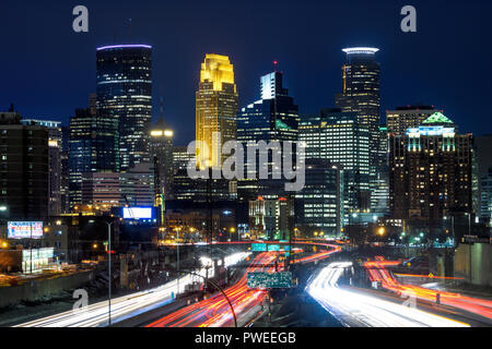 Sentieri di luce e di Minneapolis, Minnesota skyline al tramonto come si vede dalla 24th Street a piedi ponte Interstate 35W. Foto Stock