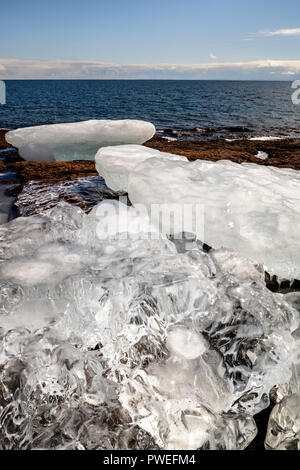 Crystal clear ice lavato fino sulla riva del Gooseberry Falls State Park. Foto Stock