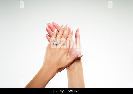 Modello femminile delle mani con platino oro bianco anello di fidanzamento con uno smeraldo diamante taglio baguette Foto Stock