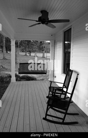 Sedie a dondolo e un banco oscillante su un tradizionale portico anteriore di una casa in Carolina del Nord. Foto Stock