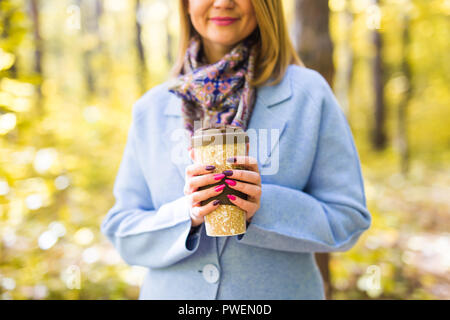 In autunno, le bevande e il concetto di persone - tazza di una bevanda calda nella donna la mano Foto Stock