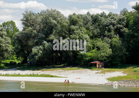 Ungheria, Kandafok sul Danubio tra Mohacs e Dunaszekcsoe, oltre Danubio, Dél-Dunántúl, Contea di Baranya, Danube-Drava National Park, Danubio paesaggio, paesaggio fluviale, dalle rive del Danubio, riverwalk, boschi, il Danubio, spiaggia sabbiosa, Strand, gente seduta sul lungomare, bagnanti, tenda, camping Foto Stock