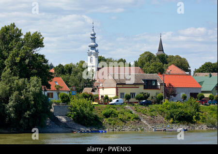 Ungheria, Dunaszekcsoe sul Danubio, oltre Danubio, Dél-Dunántúl, Contea di Baranya, Danube-Drava National Park, vista città, a sinistra la chiesa ortodossa serba, barocco, a destra la chiesa cattolica romana, Chiesa della Visitazione, edifici residenziali, dalle rive del Danubio, paesaggio fluviale Foto Stock