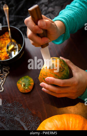 Foto di donna di mano con zucca e coltello Foto Stock