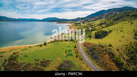 Avvolgimento su strada attraverso il lago e le montagne. Antenna di Scenic panorama di Australia Foto Stock