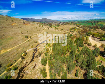 Vista aerea del Adelong creek, alberi e colline sulla luminosa giornata di sole. NSW, Australia Foto Stock