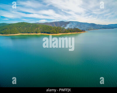 Vista aerea del fumo che sale dalla foresta sul lago Foto Stock