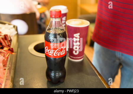 Il cliente con la costa coffee cup e coke sul contatore. Foto Stock