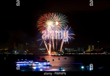 Fuochi d'artificio esplorato oltre il paesaggio urbano di notte nel porto di mare a Pattaya.vacanza festosa celebrazione sfondo Foto Stock